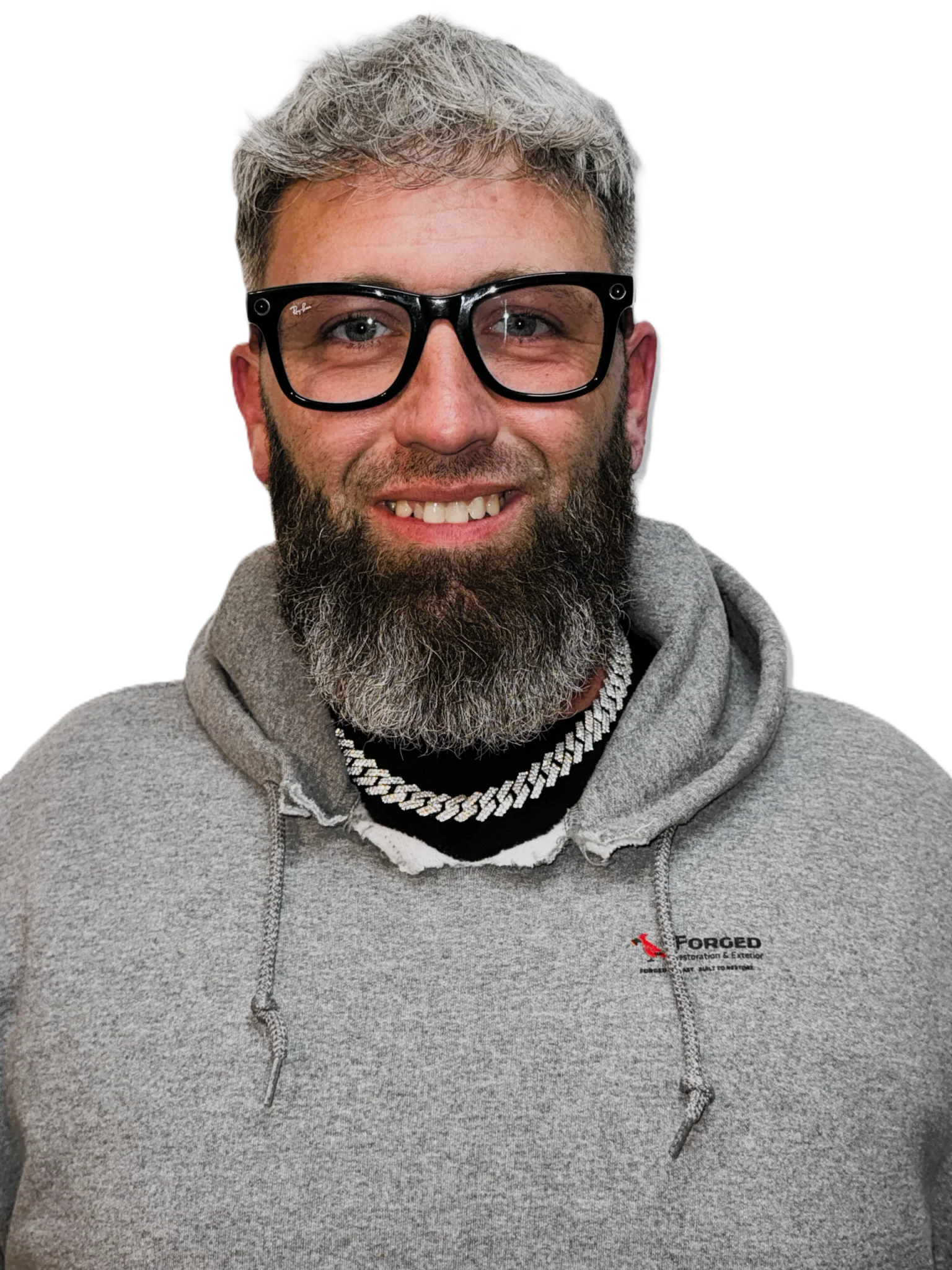 The owner is a man with grey hair, glasses, and a dark beard, dressed in a grey company sweatshirt.