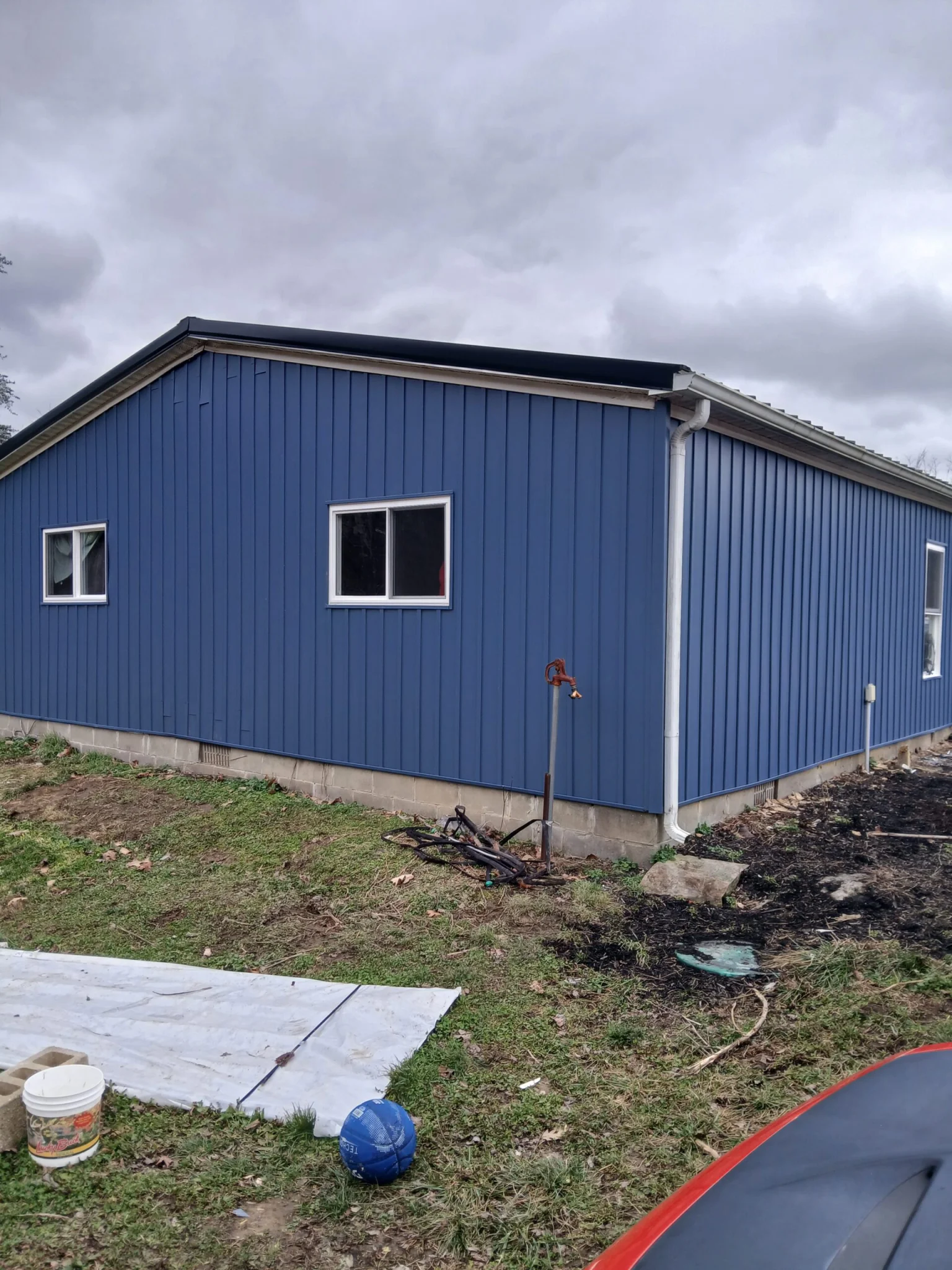 Regatta Blue Vertical Board and Baton Siding Black Metal Roof